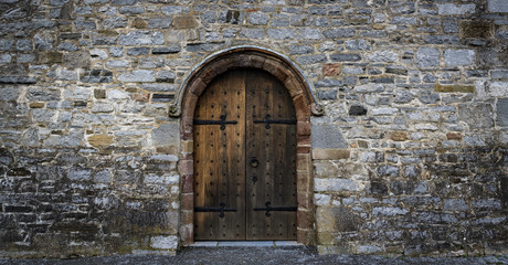 medieval castle wooden door, stone wall panorama