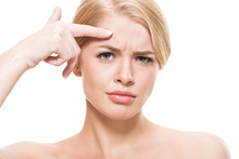 Unhappy Young Woman Pointing At Wrinkles On Forehead And Looking At Camera Isolated On White