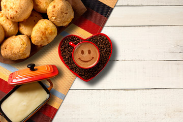 Wall Mural - Cheese buns and Red cup and coffee saucer in heart shape with decorated coffee on old wood background. Top View. Smile shape in coffee.