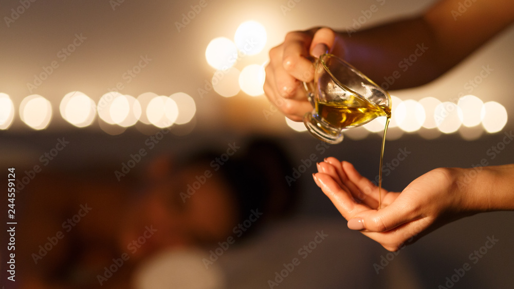 Masseur pouring massage oil, woman lying on background - obrazy, fototapety, plakaty 