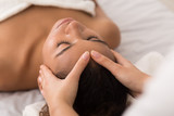 Woman enjoying anti aging facial massage in spa salon