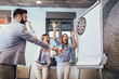 © Mediteraneo - Business people making team training exercise during team building seminar, play darts