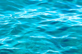 Fototapeta  - Underwater scenery, deep blue water of the ocean, air bubbles, waterline splitting skyline, divers discovering sea
