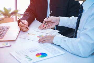 Wall Mural - Businessman is deeply reviewing a financial reports for a return on investment or investment risk analysis on a laptop computer notebook.