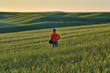 © sergnester - girl in the field. hilly spring field. tourist meditates in the field. Alone with nature