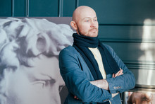 Portrait Of Attractive Adult Successful Bald Man Art Critic Historian With Beard In Scarf In Art Gallery