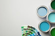 Paint cans and color palette on white background, top view. Space for text