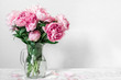 beautiful bouquet of pink peony flowers in vase. womans day or wedding background with copy space
