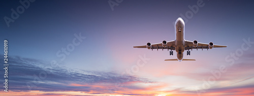 Commercial airplane jetliner flying above dramatic clouds. Fototapet