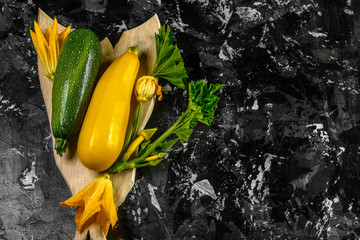 Wall Mural - Fresh organic summer vegetables zucchini on chopping board on rustic background. Top view, space for text