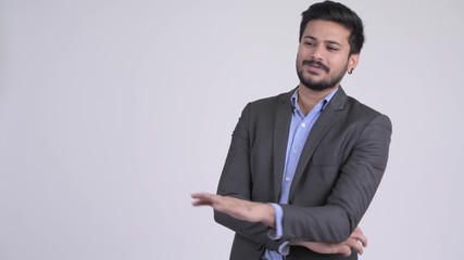 Wall Mural - Young happy bearded Indian businessman talking