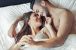 © Alessandro Biascioli - Happy romantic couple embracing in the bed - Young lovers having a tender and intimate moments looking each other in the bedroom - People, Love and reletionship concept