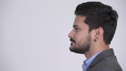 Wall Mural - Profile view of young handsome bearded Indian businessman wearing suit