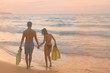 © Pinyaphat - Happy Romantic Young Asian Couple Enjoying Beautiful Sunset Walk on the Beach. Cheerful couple Holding With Mask And Flippers For Snorkel On Sunset Time. Travel Vacation Lifestyle Concept.