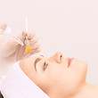 © elenavolf - Young woman cleaning face skin in salon. Retinol peel with brush. Acid organic peeling