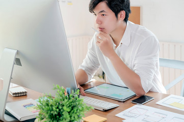 Asian confident designer working in his studio.