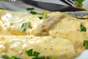 Piece of marinated herring with mayonnaise sauce on the plate