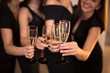 © melana365 - Cheers! Group of people cheering with champagne flutes with holiday lights on background with copy space.