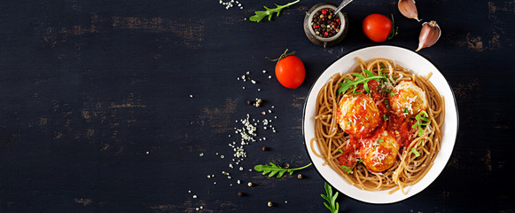 Italian pasta. Spaghetti with meatballs and parmesan cheese in bowl on dark rustic wood background.  Dinner. Banner. Top view. Slow food concept