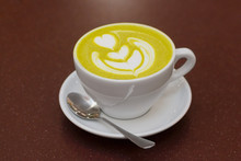 A Cup Of Green Tea Matcha Latte With Heart Latte Art On Top.