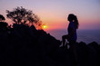 © THANAGON - Happy woman enjoying on the top of the mountain at sunset.