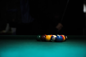 Wall Mural - Sport billiard balls set arranged in shape of triangle on green billiard table in pub. Players are ready for the first hit of the round to start the billiard game.