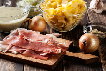 Wall Mural - Ingredients ready for preparing pappardelle with prosciutto and cheese sauce