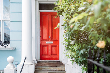 Beautiful red door in a white house facade in Notting Hill