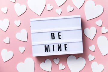 Wall Mural - Be mine lightbox message with white hearts on a pink background