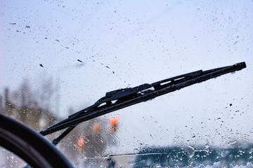 Wall Mural - dirty car windshield with the included glass cleaner, in the big city front and back of the background is blurred