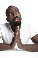 Wall Mural - Portrait of a young serious african man at studio. High fashion male model posing and isolated on white background