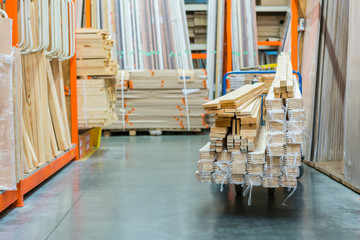 construction cart in the building store. Carts loaded with boards. shop of building materials. Racks with boards, wood and building material. loaded cart in a hardware store.