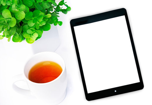 
Tablets with a cup of tea and a flower on the table, business concept