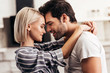 © LIGHTFIELD STUDIOS - handsome boyfriend and attractive girlfriend hugging and smiling in kitchen