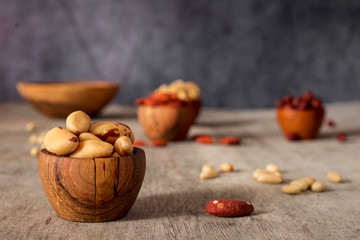 Wall Mural - Hazelnuts, cashews, Brazil nuts and almond wooden bowls on a gray background.