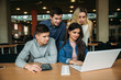 © Aleksandr - Group of college students studying in the school library, a girl and a boy are using a laptop and connecting to internet. Prepare for an exam