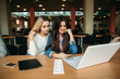 © Aleksandr - Two girl student use tablet and laptop in library. And listen music
