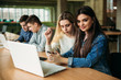 © Aleksandr - Group of college students studying in the school library, a girl and a boy are using a laptop and connecting to internet. Prepare for an exam