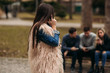 © Aleksandr - Young people having a good time in park. Male and female sitting on the bench and using phones