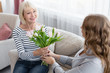 © Prostock-studio - Senior mother receiving birthday flowers from daughter