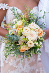 Wall Mural - the bride is holding a rustic wedding bouquet of flowers and various herbs