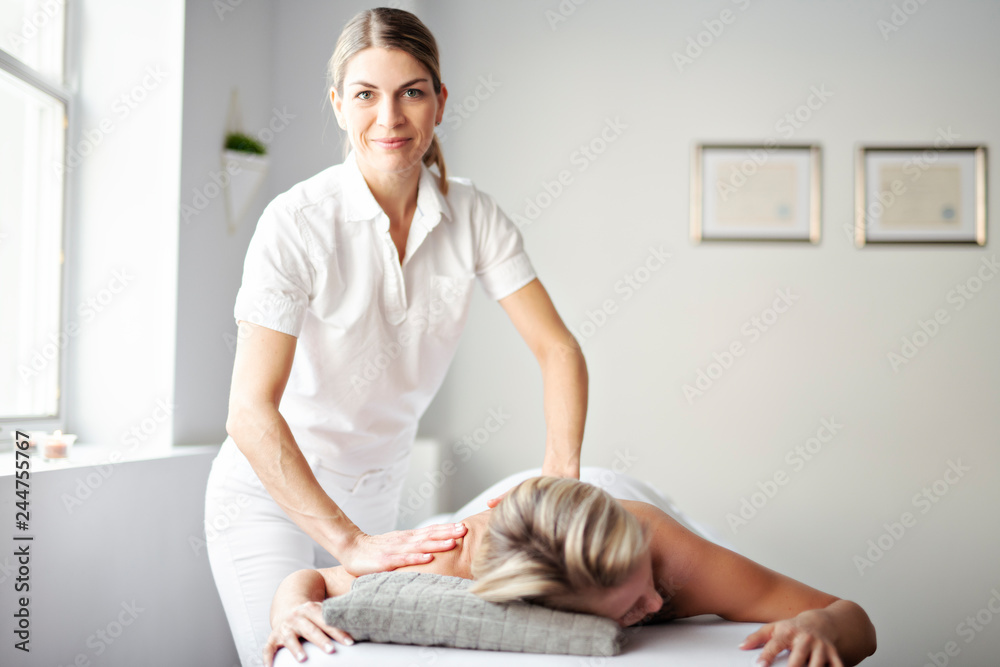A Woman enjoying spa treatment at salon with masseur worker - obrazy, fototapety, plakaty 