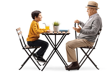 Poster - Mature man sitting at a coffee table and talking to his grandson