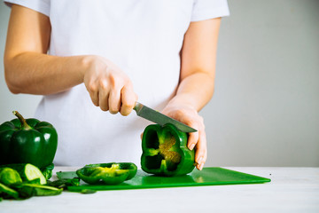 woman cut green paper on green kitchen board