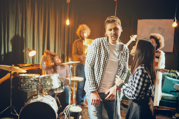 Sticker - Singers practicing for duet. In background band playing. Home studio interior.