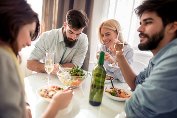 Wall Mural - Group of friends enjoying meal at home together