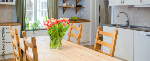 Fotomural banner tulips on the kitchen table with interior in the background