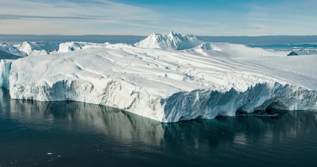 Wall Mural - Iceberg aerial drone video - Global warming and climate change concept. Giant icebergs in Disko Bay on greenland in Ilulissat icefjord from melting glacier Sermeq Kujalleq Glacier, Jakobhavns Glacier.