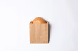 Paper bag with sesame bun on white background, top view. Space for design