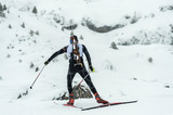 Fototapeta Londyn - Winter sports. A participant in a biathlon competition, in a winter season in Spain, in a snowy landscape.
